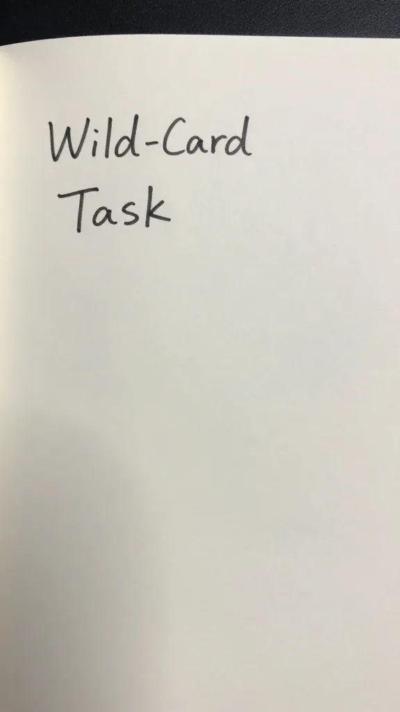 Closeup of a single wild-card task note on a plain desk pad